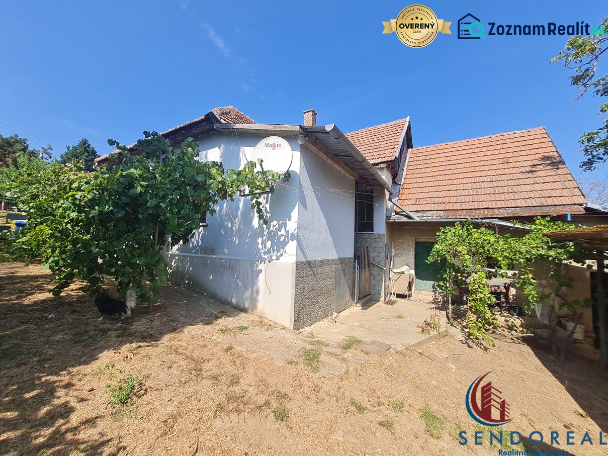 Ein Einfamilienhaus in Dolné Otrokovce mit weißem Putz und Ziegeln, grüne Pflanzen im Garten.