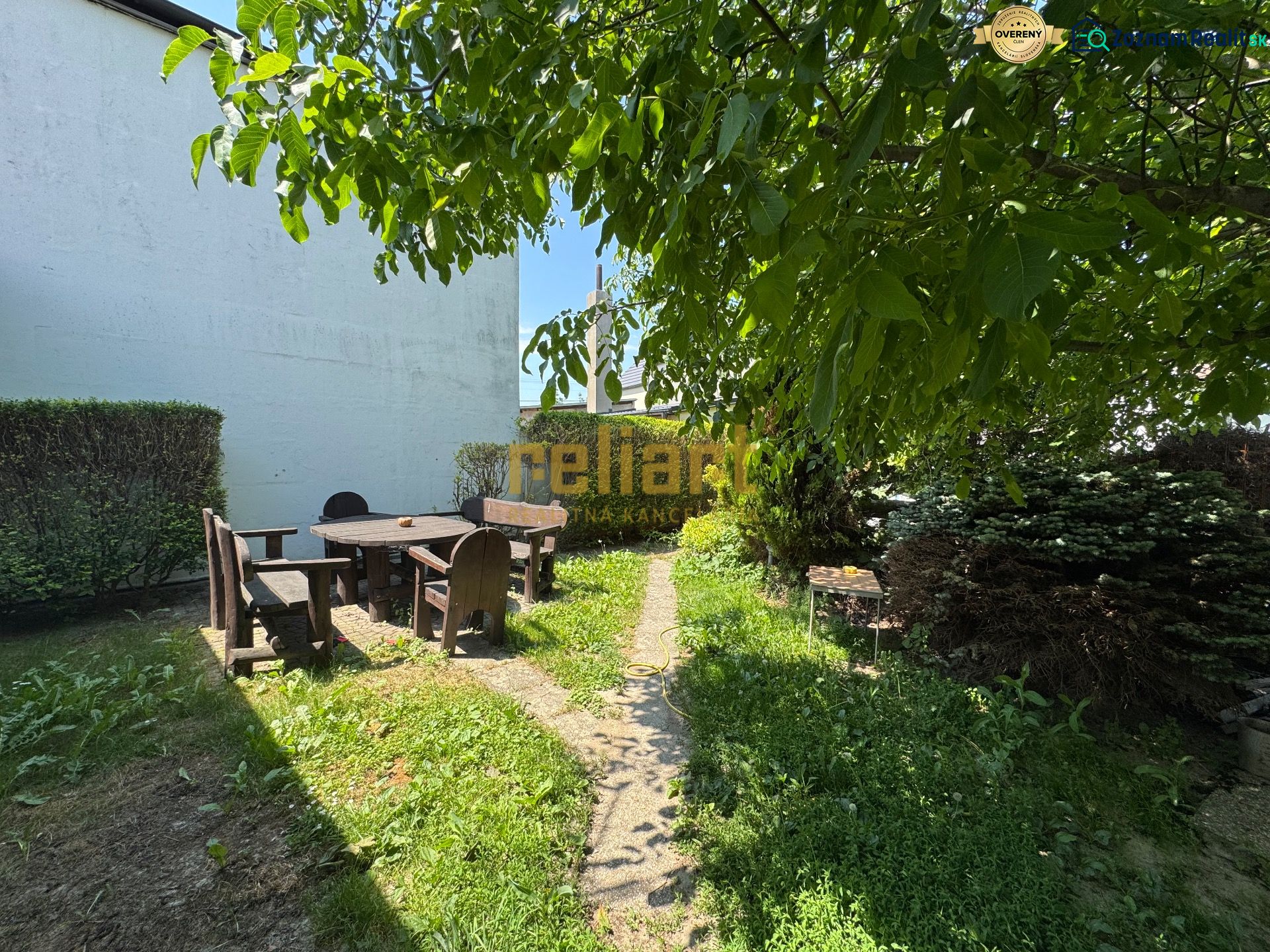 Der Garten des Einfamilienhauses in der Senna-Straße in Bratislava - Ružinov, mit einer Sitzgelegenheit im angenehmen Schatten.