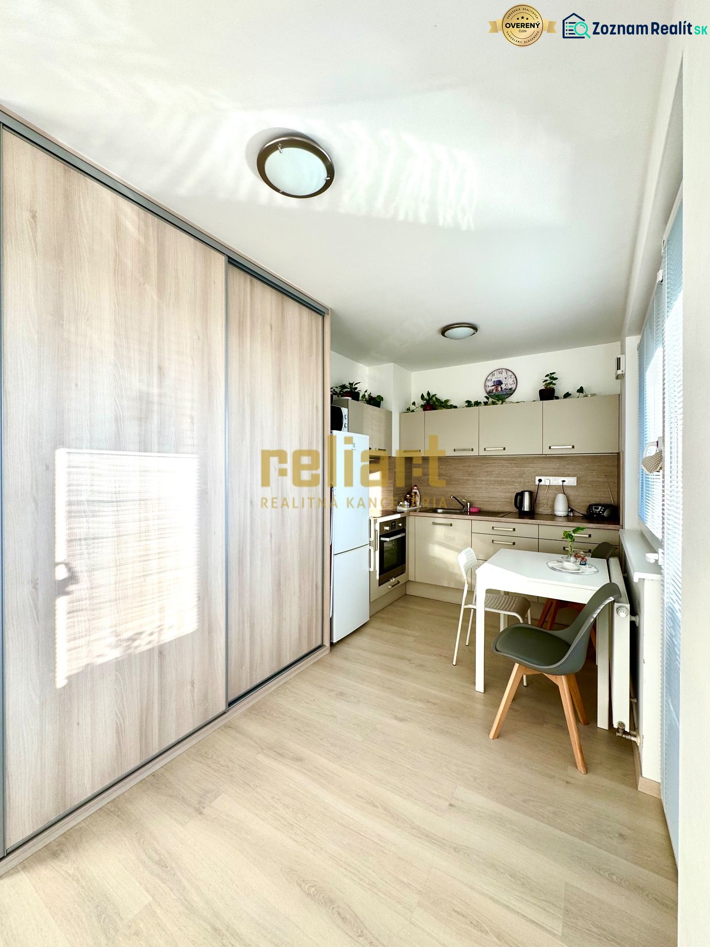 Küchenecke mit Holzboden und Einbauschrank in einer Einzimmerwohnung.