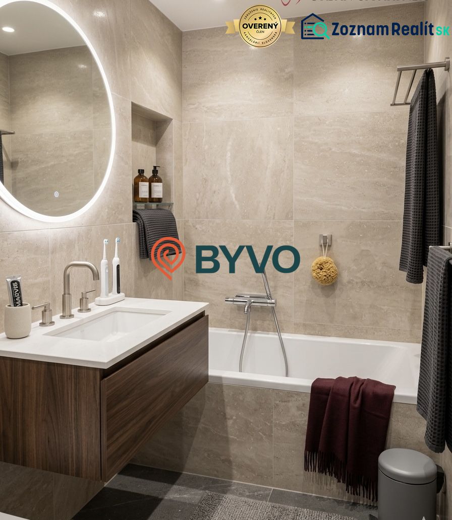 Badezimmer mit Badewanne, hängendem Waschbecken und rundem beleuchtetem Spiegel in einer 2-Zimmer-Wohnung.