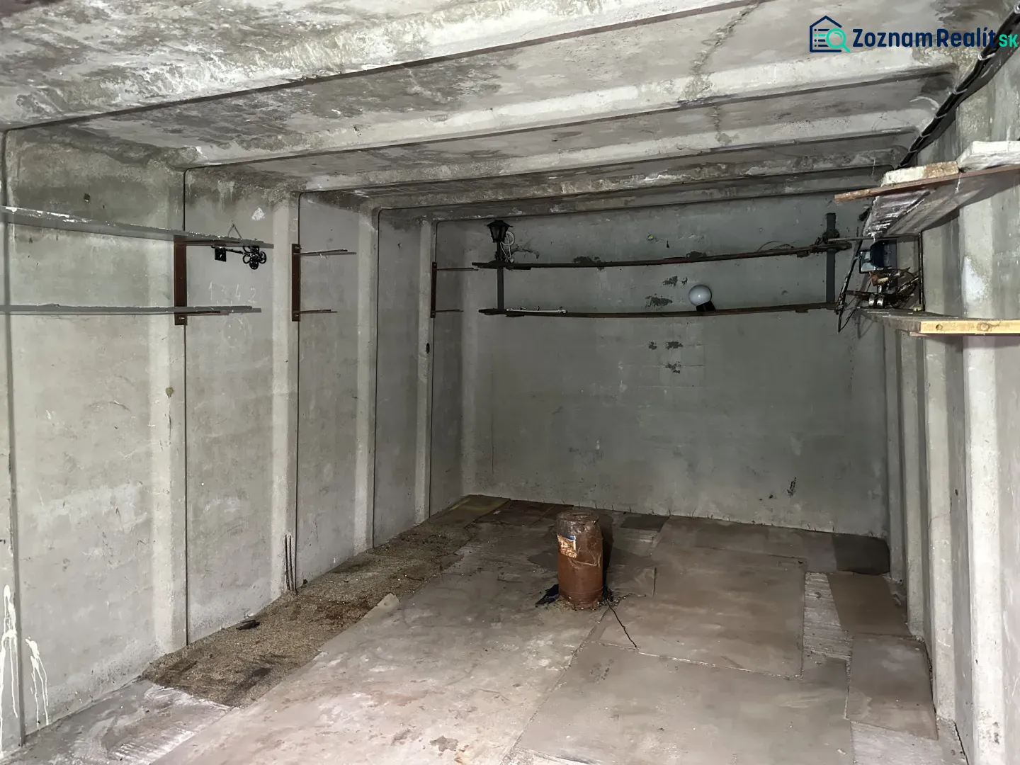Leerer Betonraum mit Rohren und Beleuchtung, Garageninnenraum.
