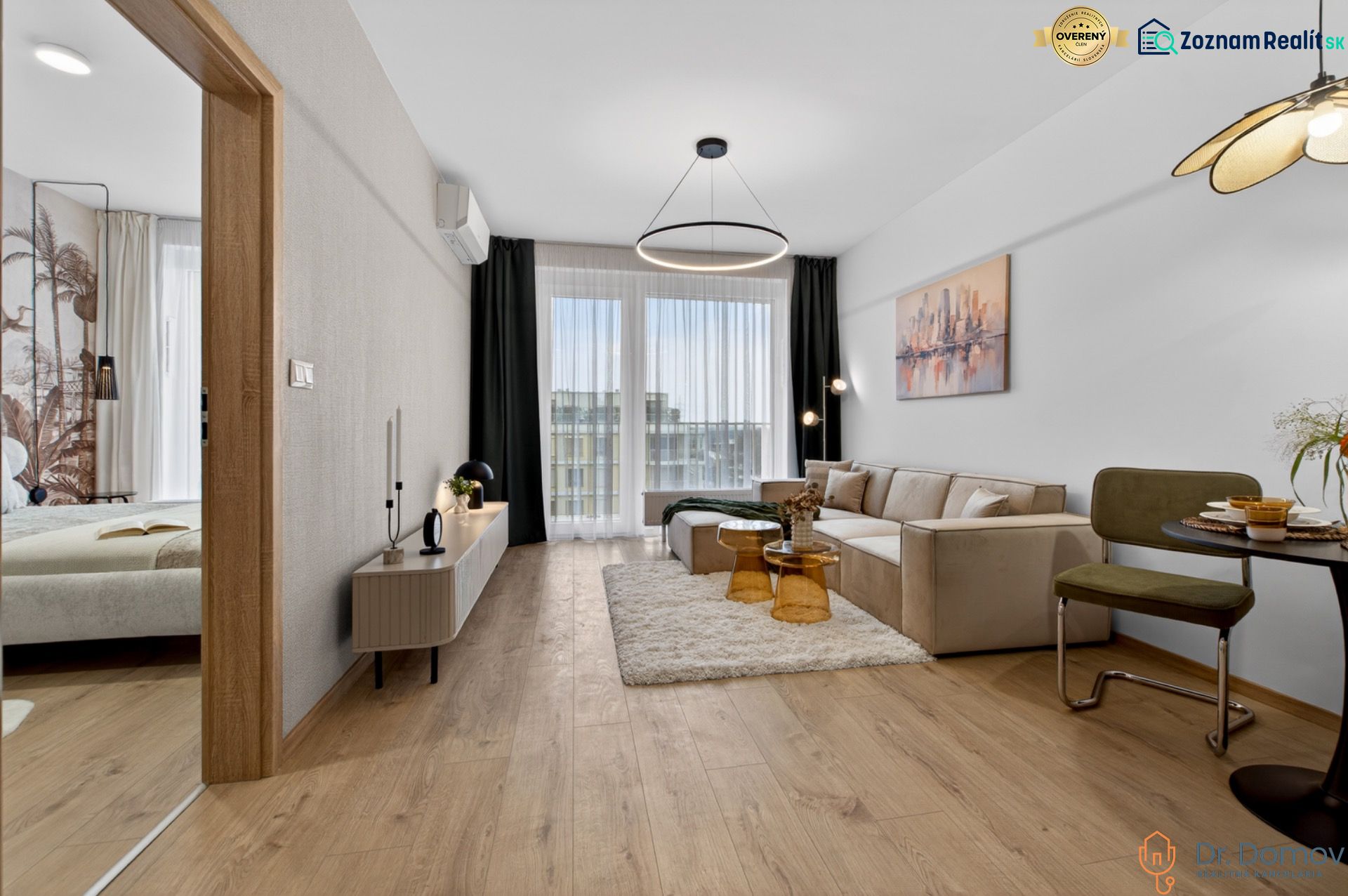 Wohnzimmer mit Sofa, Essecke, Holzboden in einer Zweizimmerwohnung.