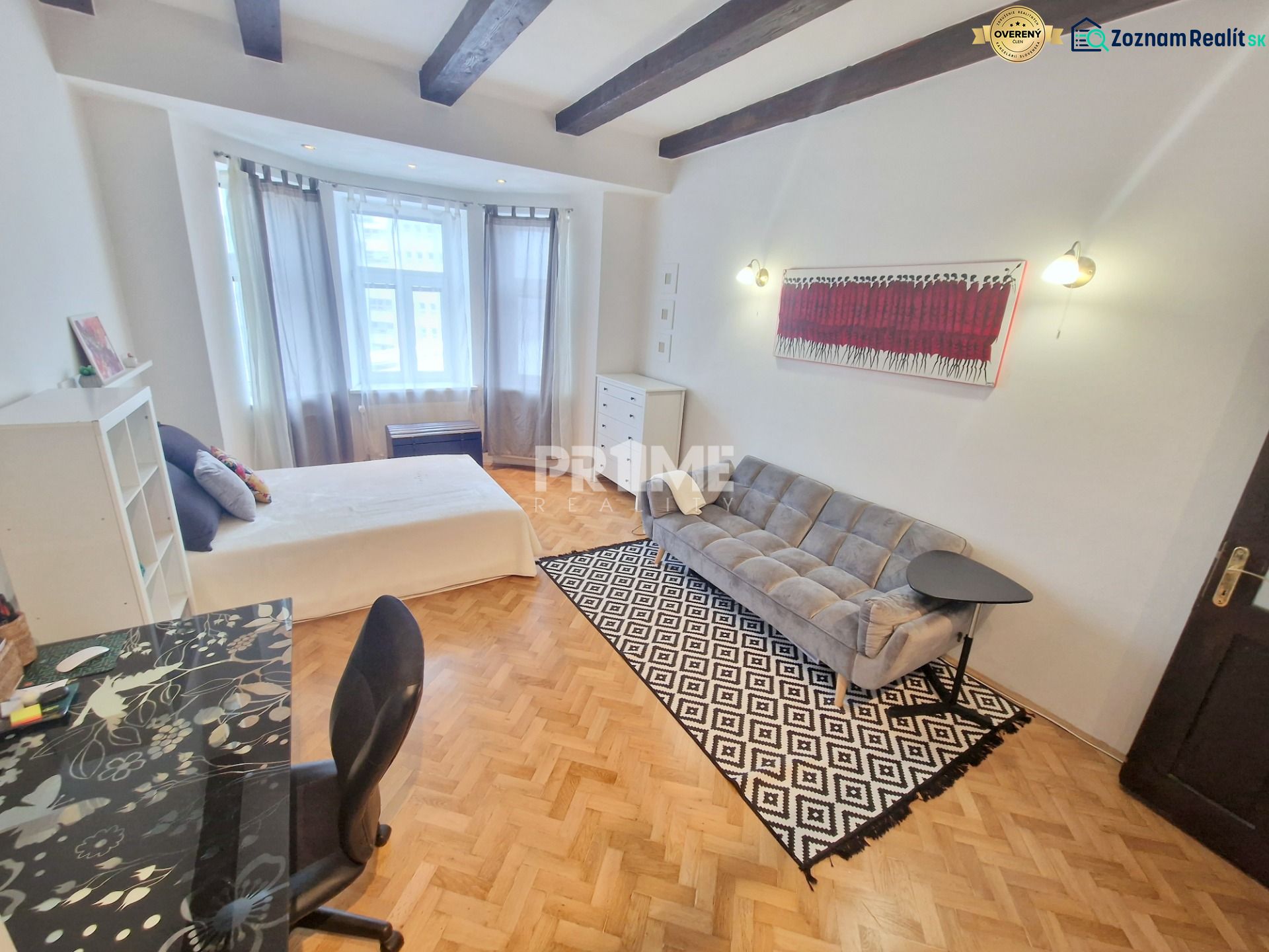 Teilweise möblierte 3-Zimmer-Wohnung mit Sofa, Tisch und Boden in Holzoptik.