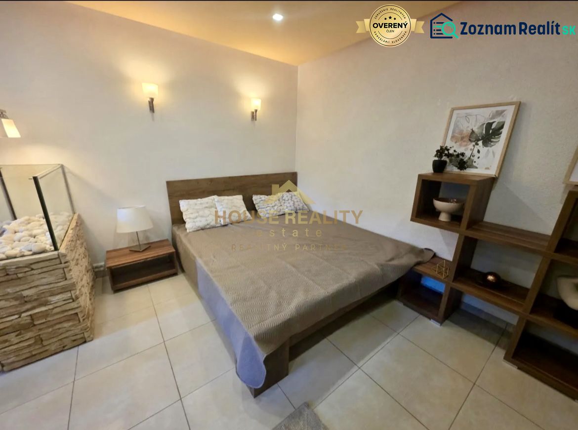 Schlafzimmer in einer Einzimmerwohnung mit stilvollem Dekor, Holzelementen, geräumigem Bett.