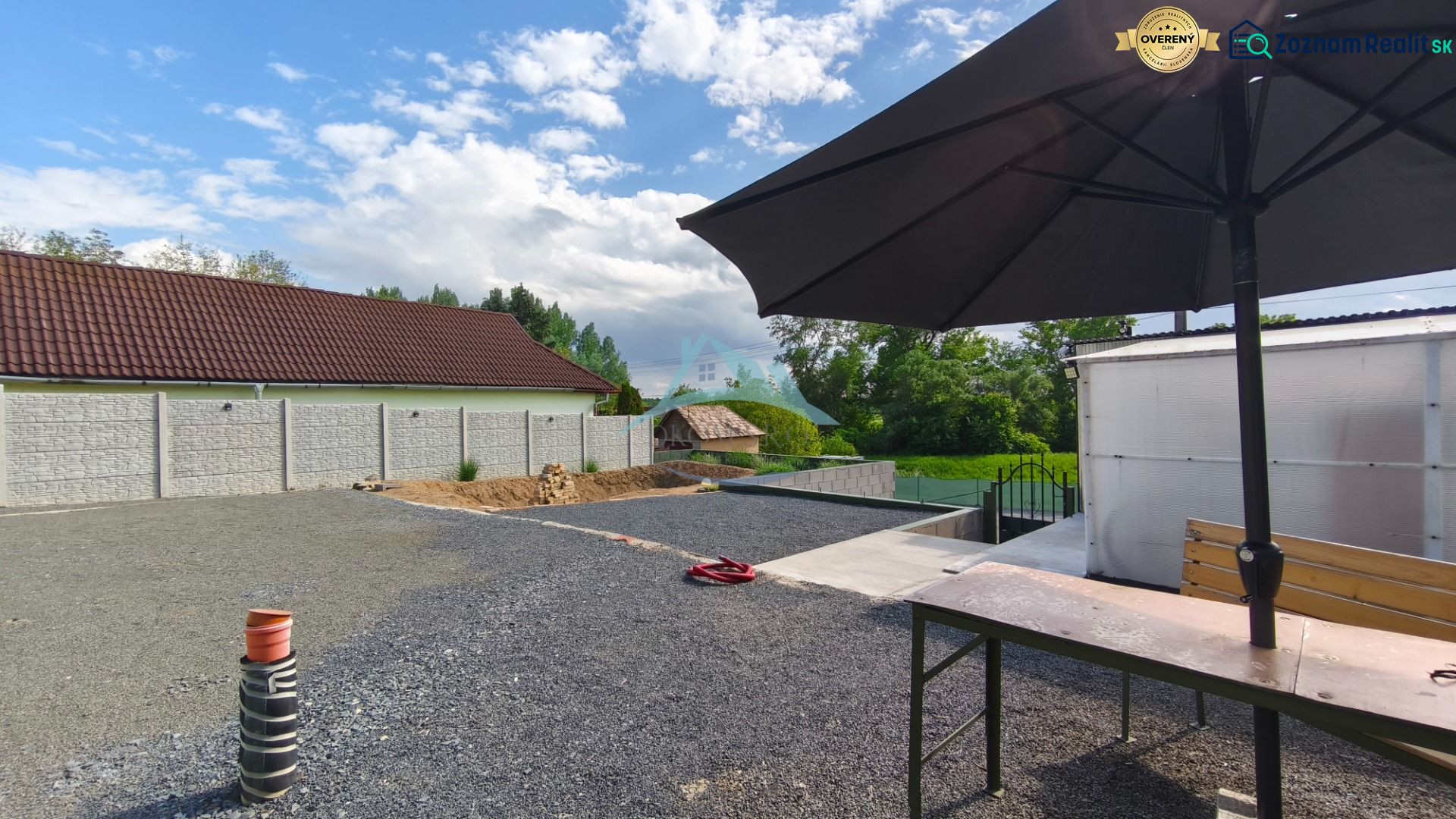 Ein Hof mit steinernem Belag und einem großen Sonnenschirm auf den Erholungsgrundstücken in Záhorce, Selešťany.