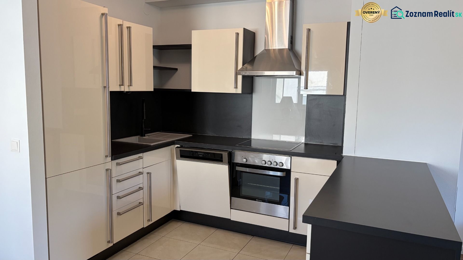 Küche in einer 3-Zimmer-Wohnung, mit passender schwarz-weißer Küchenzeile und Geräten.