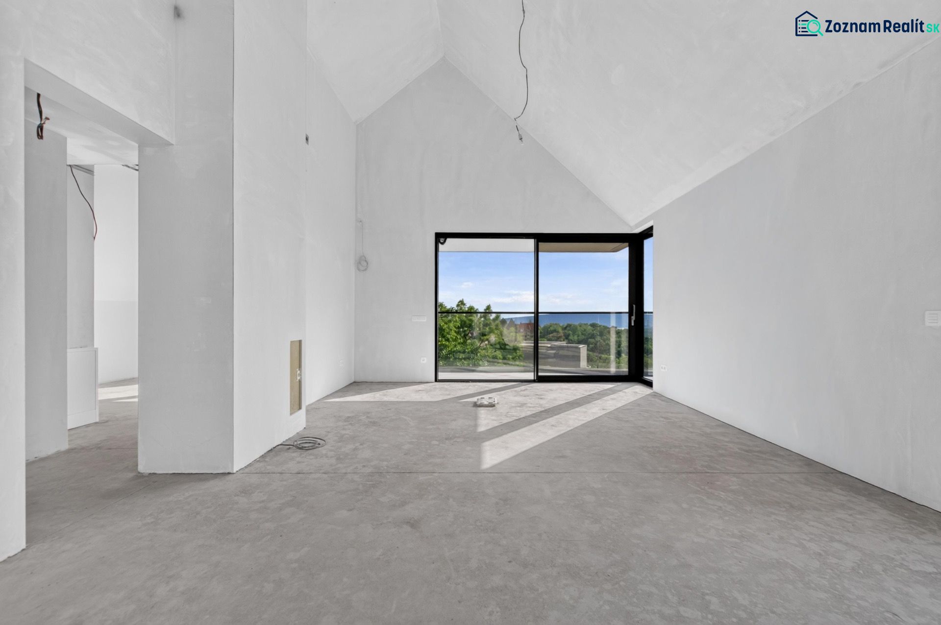 Ein geräumiges Wohnzimmer mit großen Fenstern in einer Wohnung mit 5 oder mehr Zimmern und Blick ins Grüne.