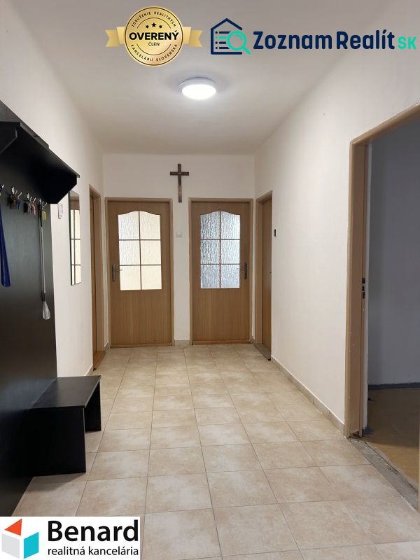 Flur in einem Einfamilienhaus mit Fliesen, Holztüren und Garderobe.