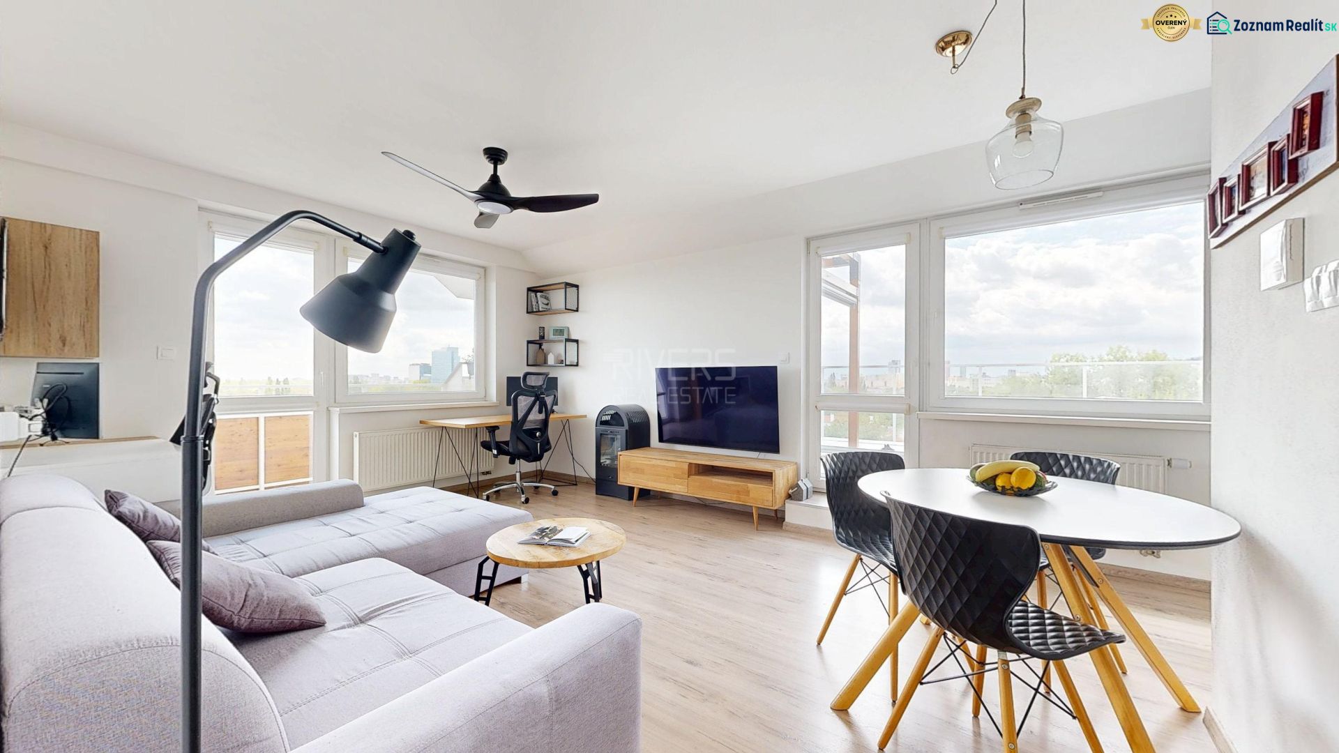Wohnzimmer in einer 3-Zimmer-Wohnung mit Holzboden und heller Couchgarnitur.