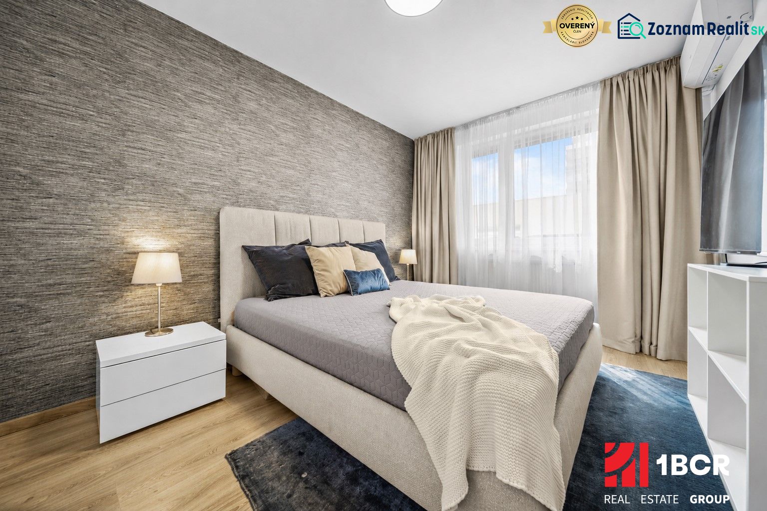 Schlafzimmer mit Bett und Nachttisch, Boden mit Holzdekor in einer 2-Zimmer-Wohnung.
