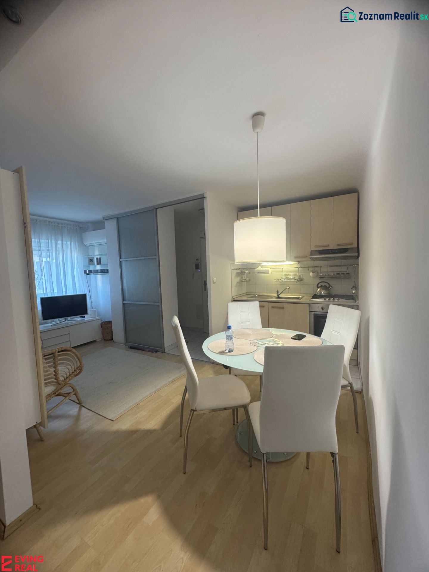 Essbereich in einer Einzimmerwohnung mit Küche und Holzboden.