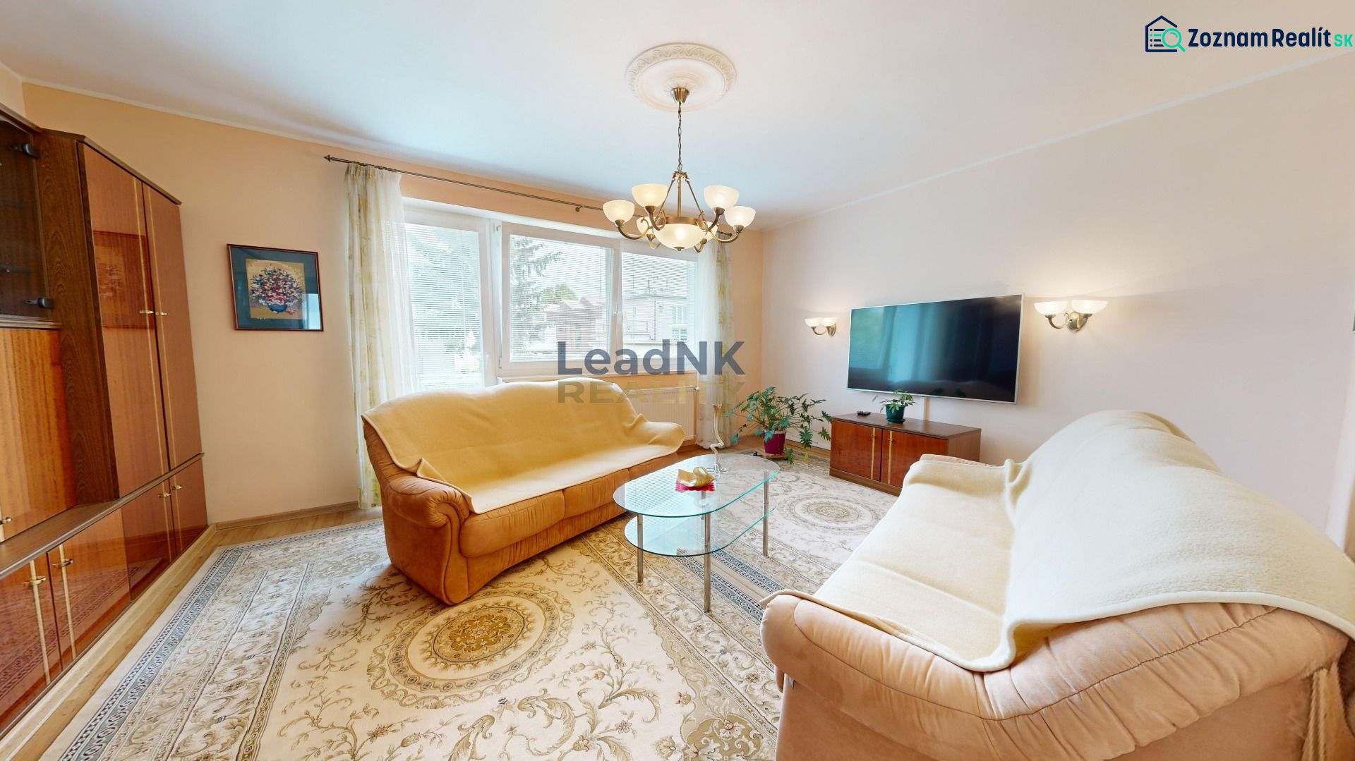 Wohnzimmer mit Teppichen, Sofas und Fernseher in einer 3-Zimmer-Wohnung.