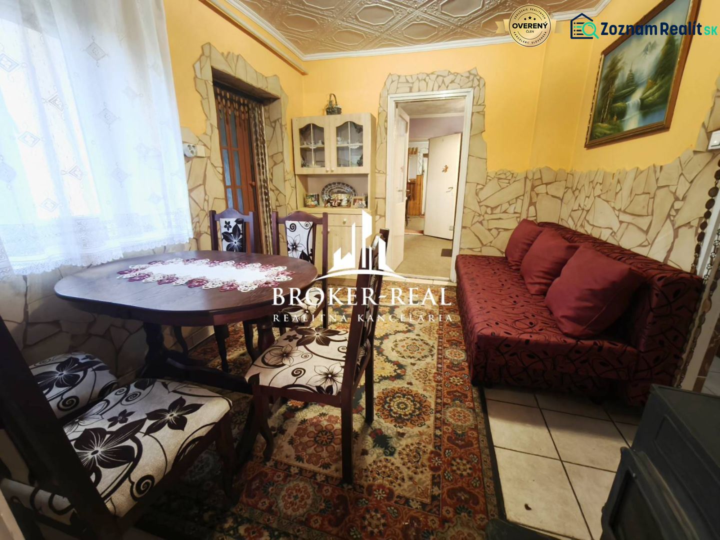 Esszimmer in einem Einfamilienhaus mit einem dekorativen Tisch und einem roten Sofa.
