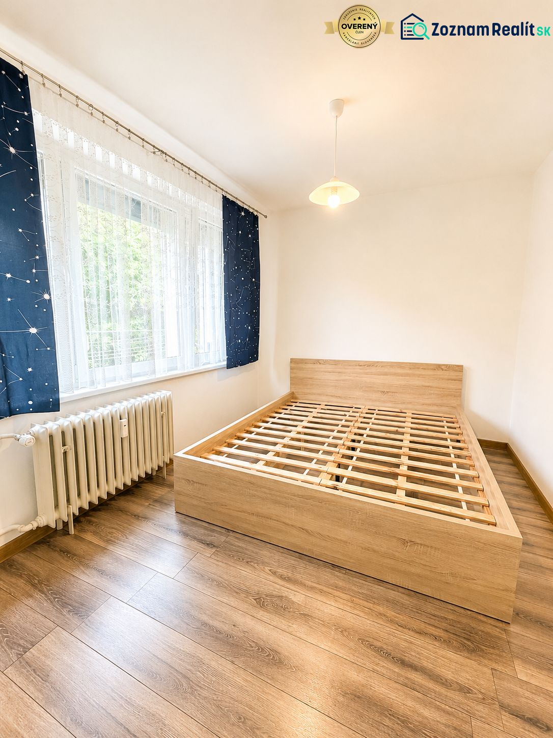 Schlafzimmer mit Holzboden und Bett in einer 3-Zimmer-Wohnung.
