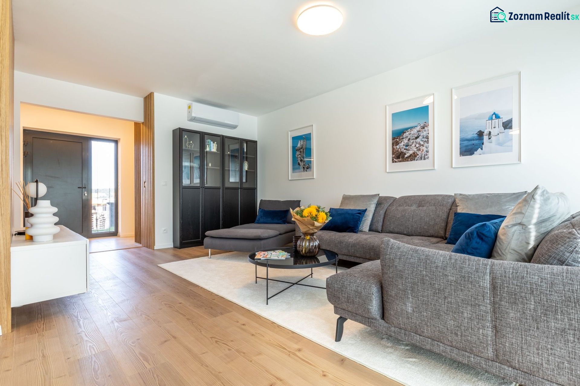Wohnzimmer in einem Einfamilienhaus mit Holzboden, Sofa und Dekorationsgegenständen.