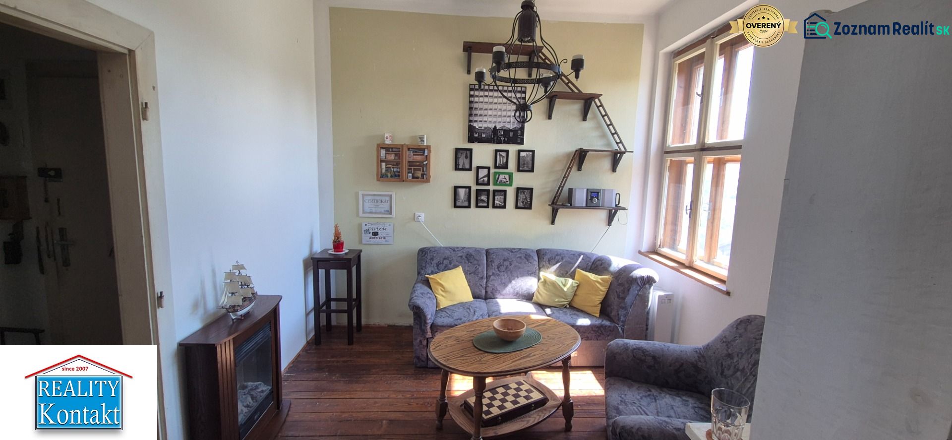 Wohnzimmer in einer 2-Zimmer-Wohnung mit Sofa, Dekorationen und Boden in Holzoptik.
