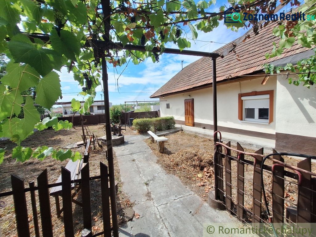 Der Hof beim Einfamilienhaus in Kamenica nad Hronom mit einer Pergola und einer Bank.