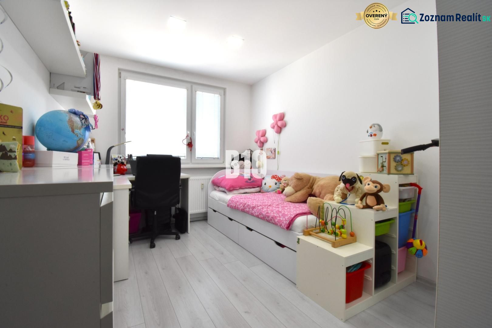Kinderzimmer in einer 3-Zimmer-Wohnung mit Spielzeug und Schreibtisch, Boden mit Holzdekor.
