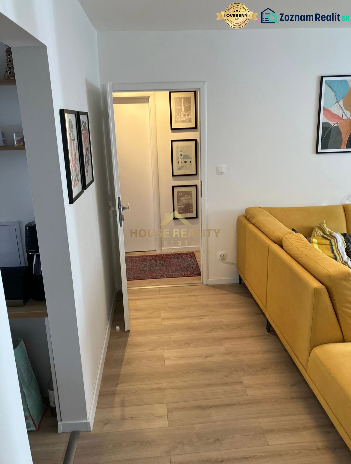 Heller Boden mit Holzdekor und gelbes Sofa in einer 3-Zimmer-Wohnung.