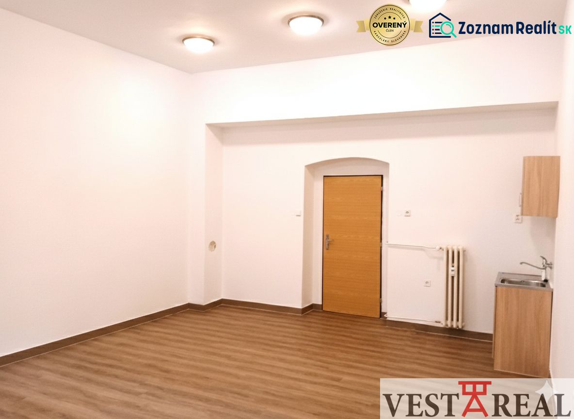 Büros mit Holzboden, weißen Wänden und einem Waschbecken.