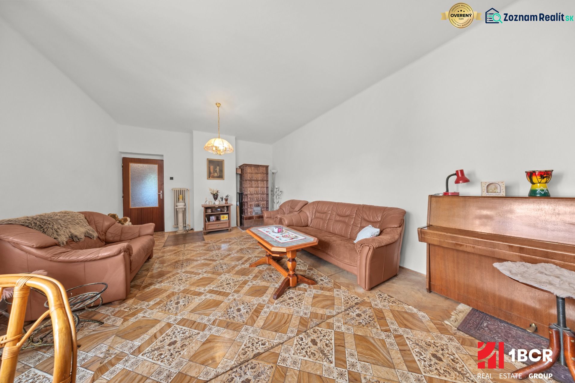Wohnzimmer in einem Einfamilienhaus mit Ledersofa, Klavier und Holzboden.