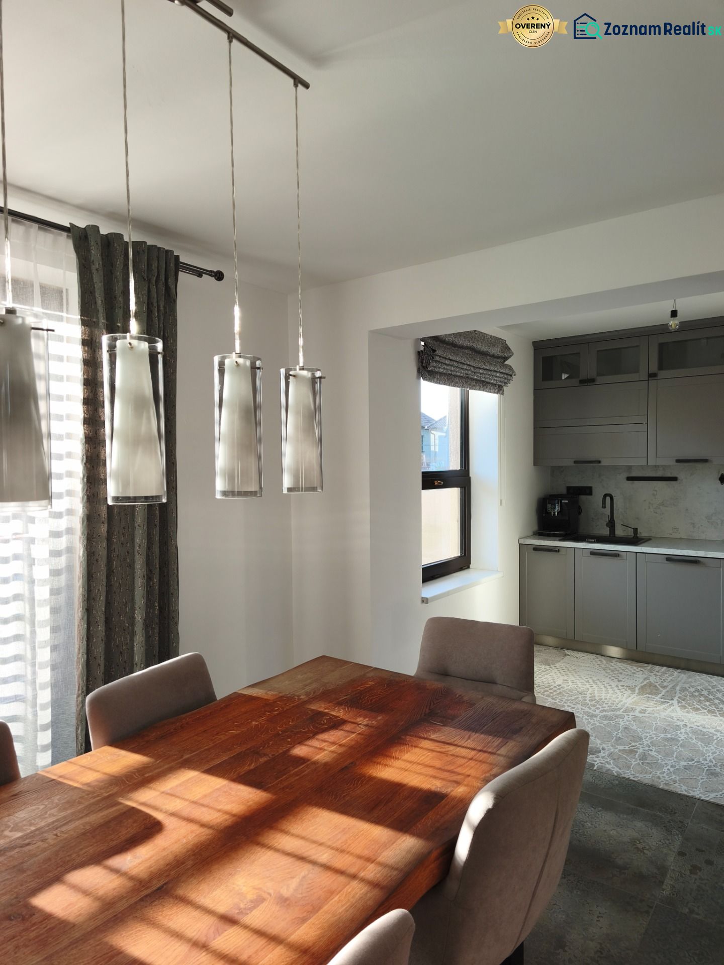 Esstisch mit Holzdekor und graue Schränke in einem Einfamilienhaus.