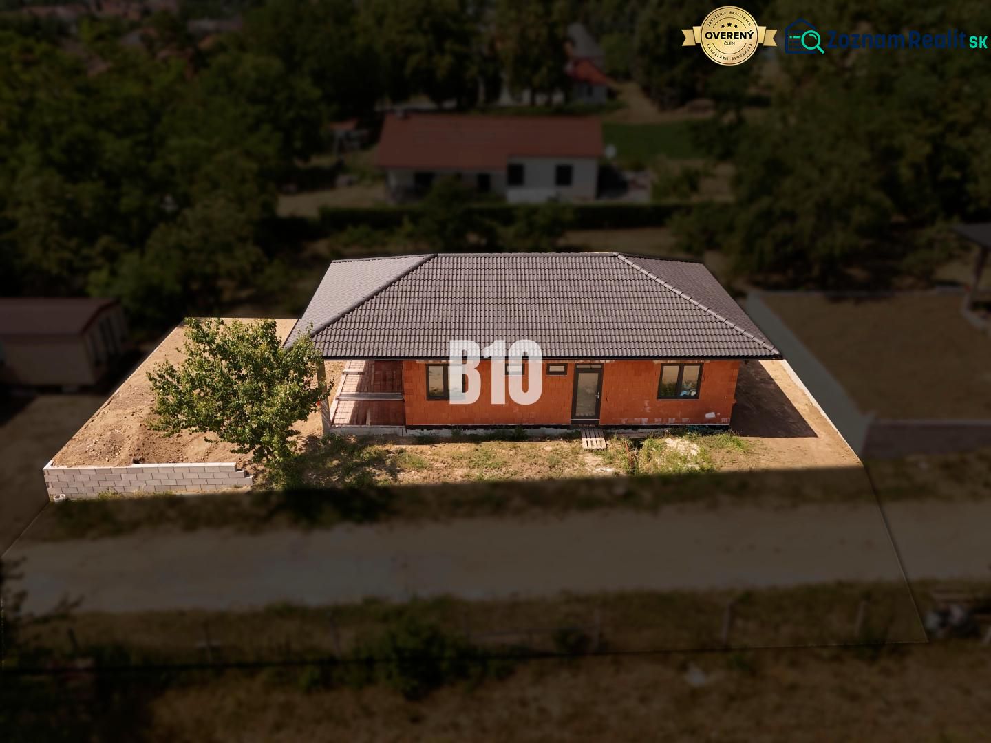 Ein Einfamilienhaus in Čeľadice mit einer Ziegelfassade, einem Schrägdach und einer Umzäunung.