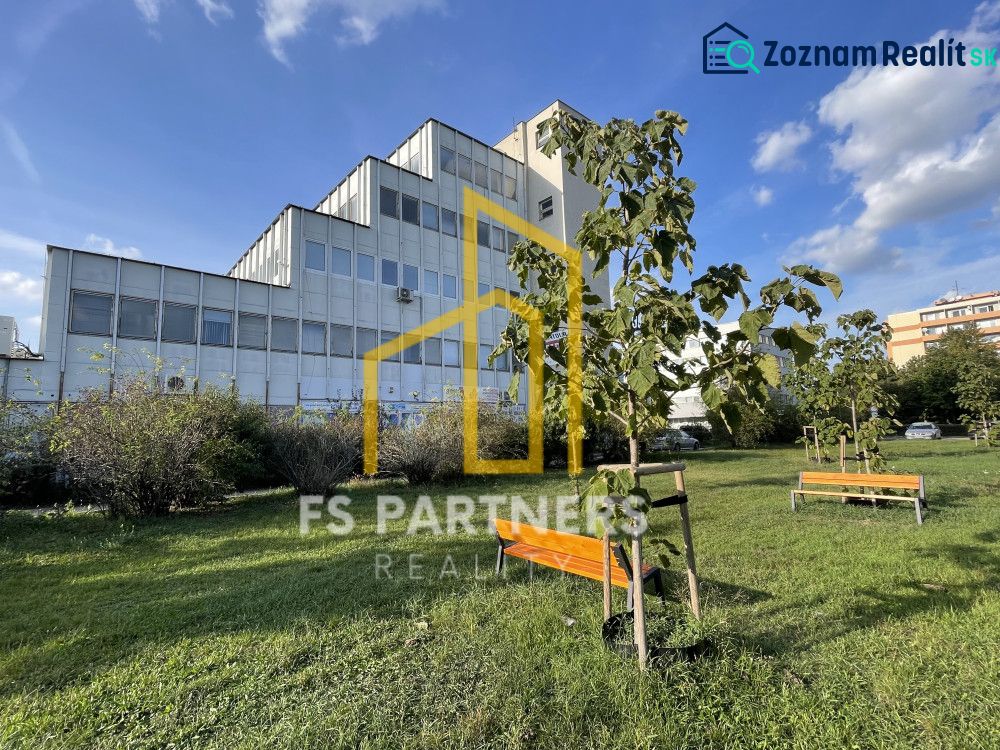 Büros in der Záhradnícka-Straße in Komárno mit Bänken und jungen Bäumen.