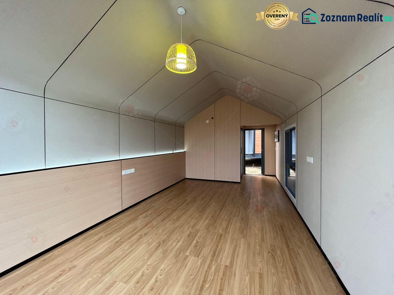 Innenraum einer Hütte mit Holzboden und einer auffälligen Hängelampe.