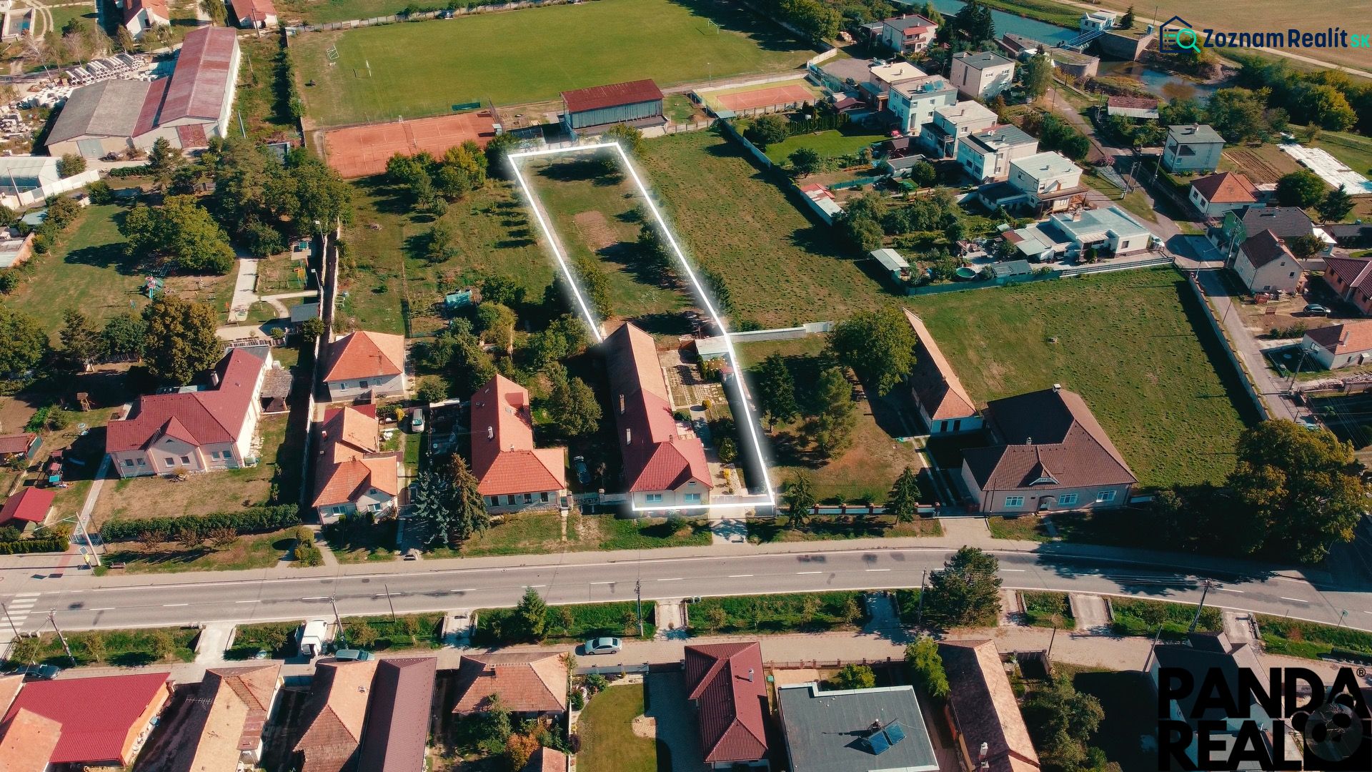Luftaufnahme von Einfamilienhäusern und Gärten in Nadlice, umgeben von Grünflächen und Straßen.