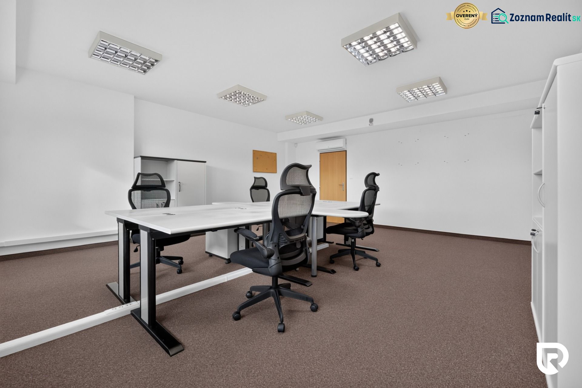 Büros mit Konferenztisch, ergonomischen Stühlen und Aufbewahrungsschränken.