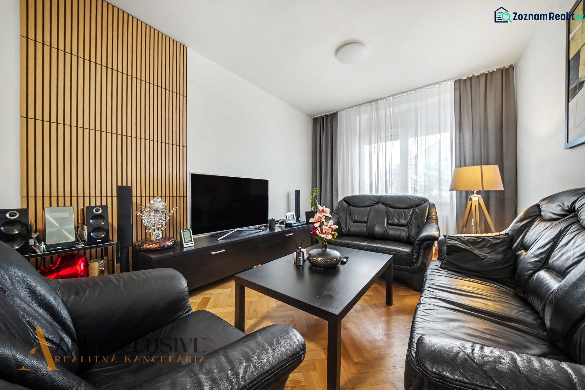 Wohnzimmer eines Einfamilienhauses mit Ledersofas und Holzboden.