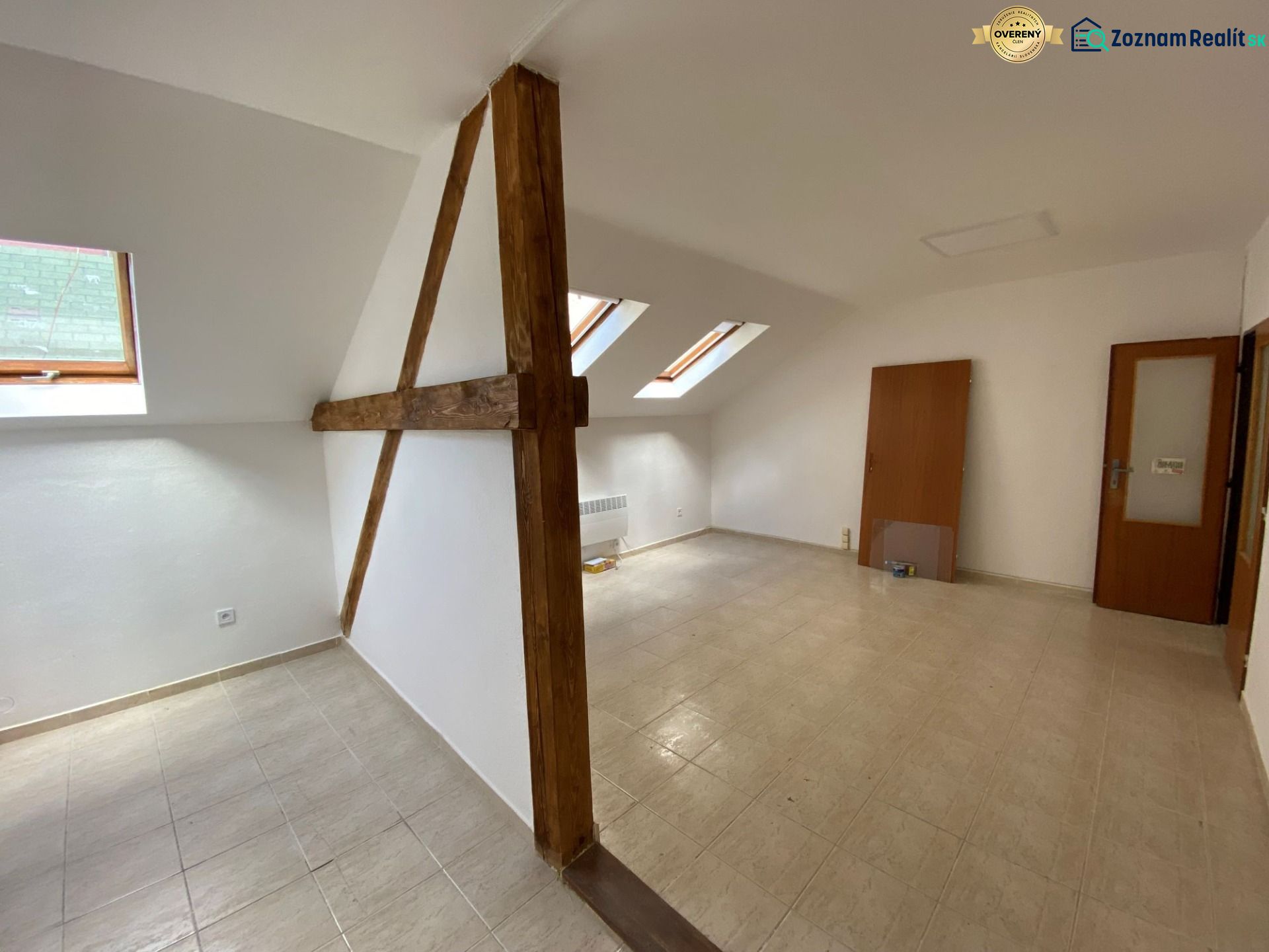 Dachbodenkantoor mit Holzbalken und schrägen Fenstern, Boden mit Holzdekor.