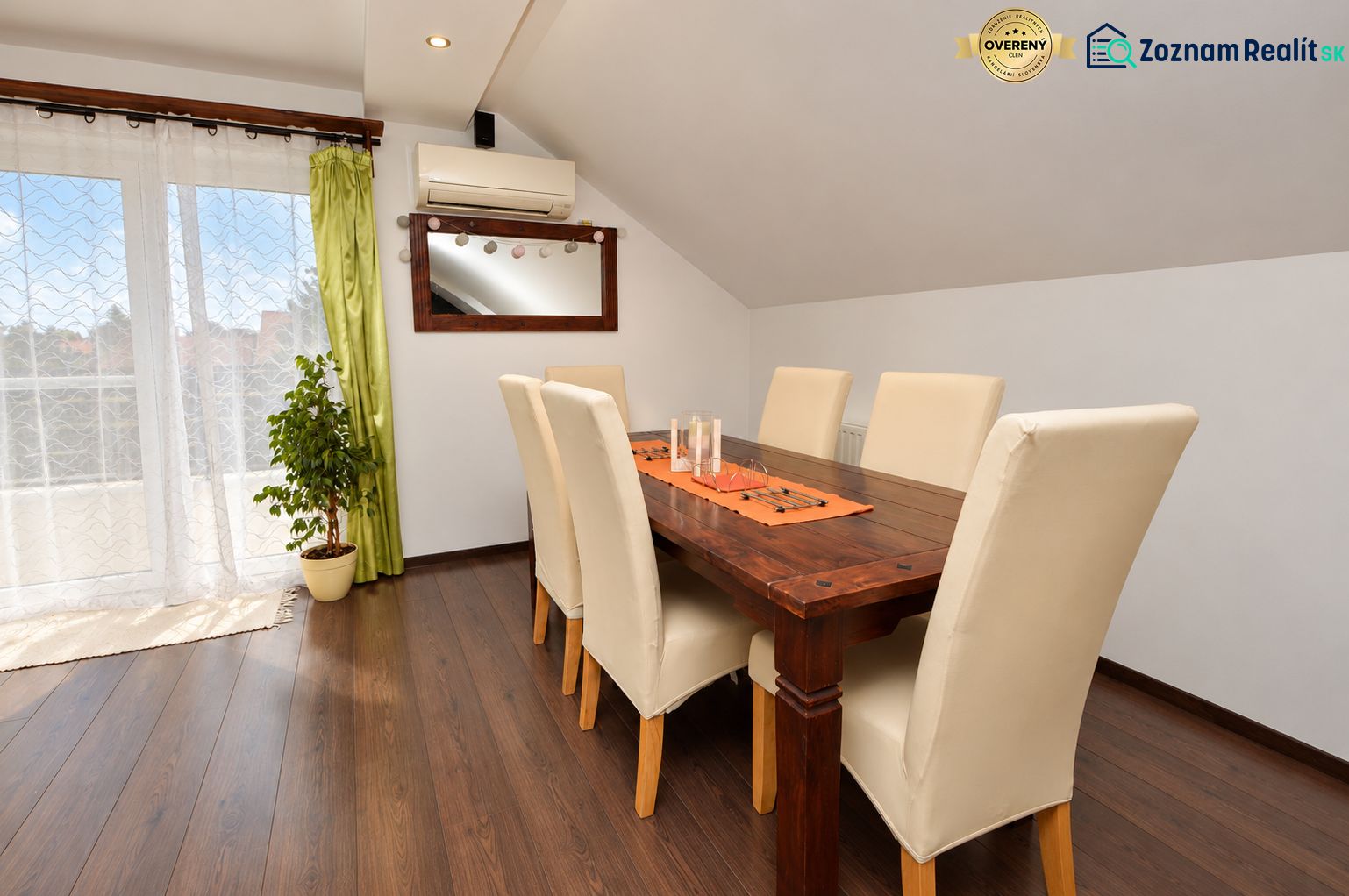 Esszimmer in einem Einfamilienhaus mit Holzboden und großen Fenstern.