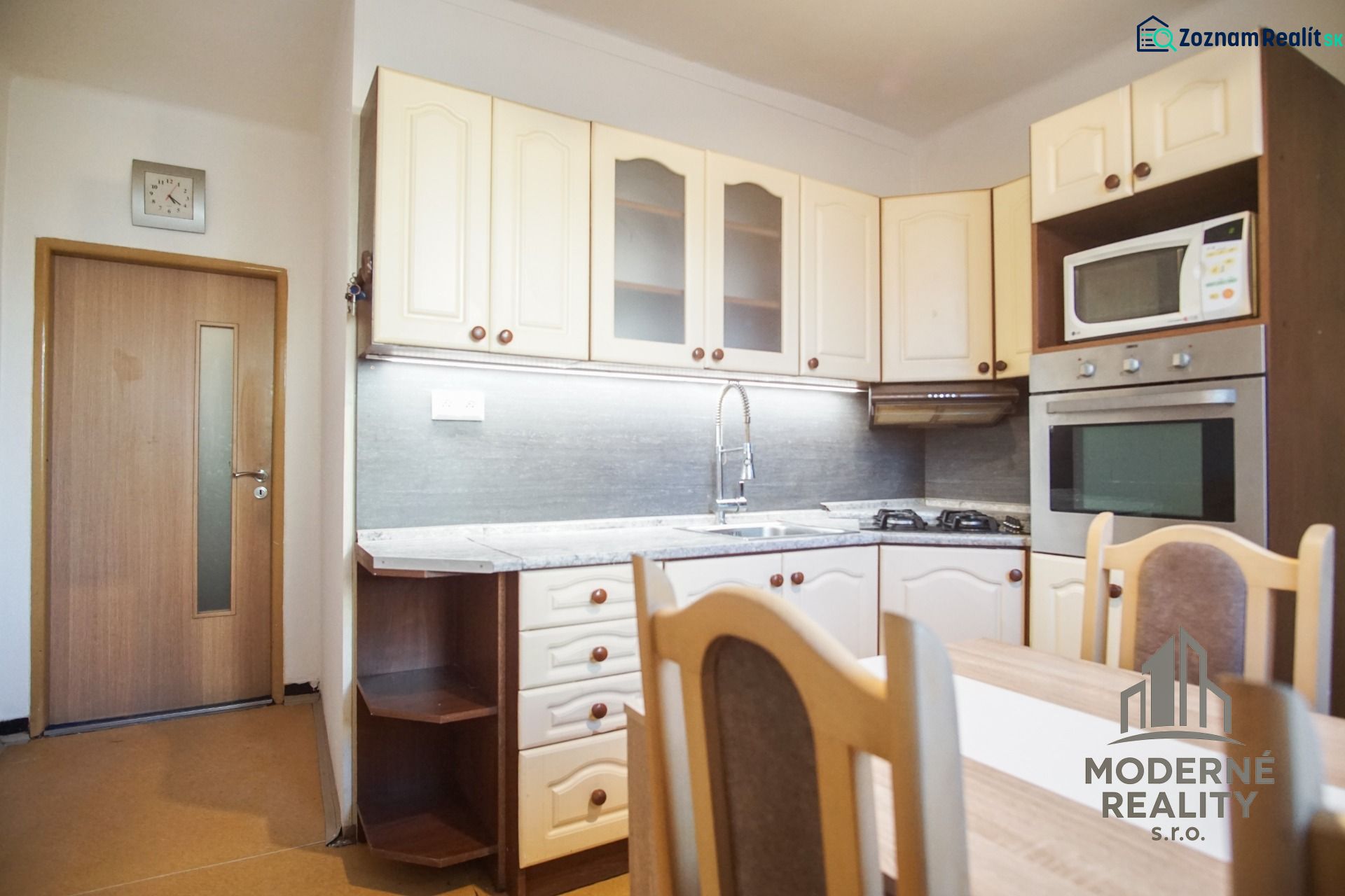 Küche in einer 2-Zimmer-Wohnung mit eingebauten Geräten und Esstisch.