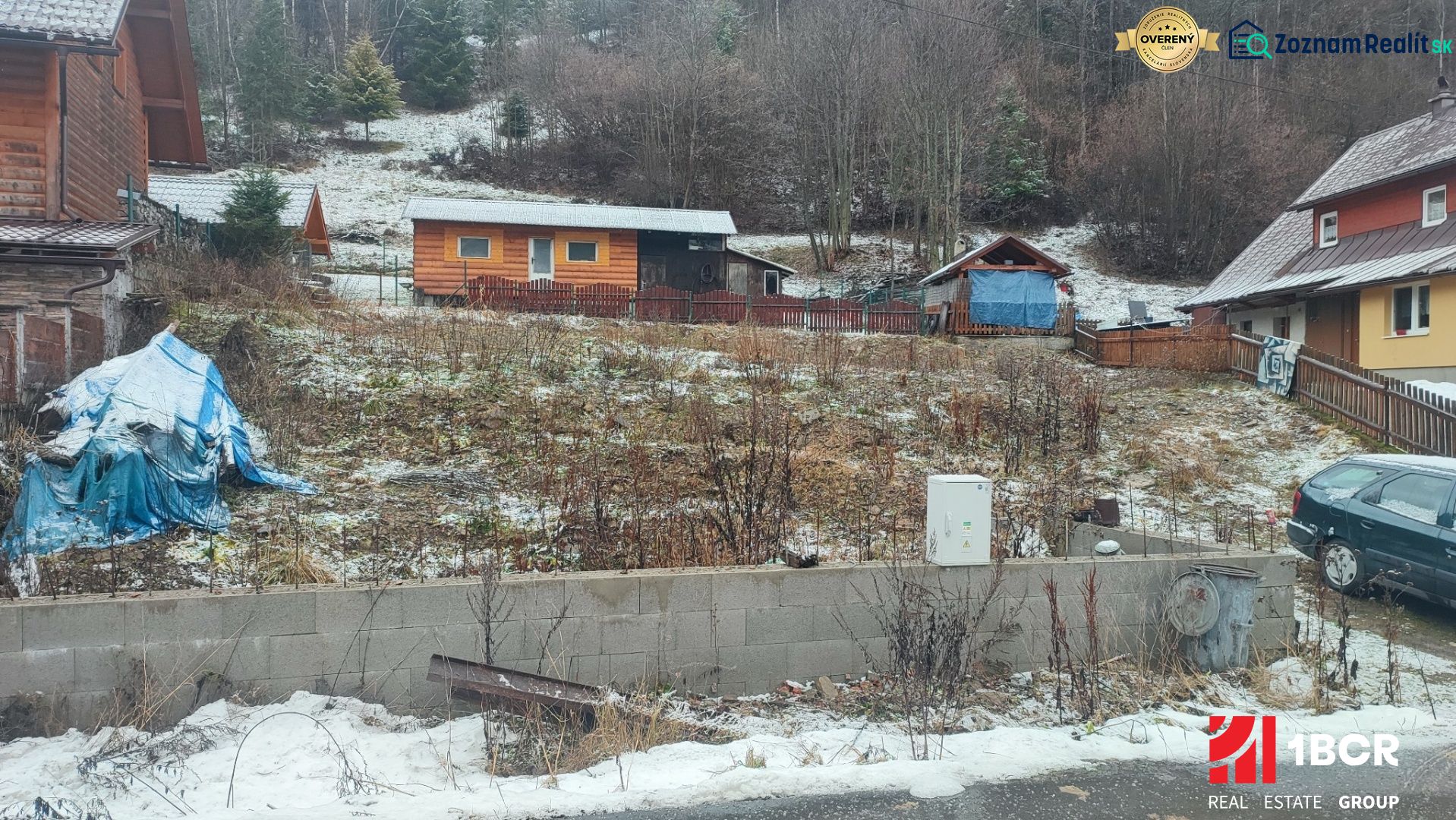 Ein verschneites Grundstück mit einem Einfamilienhaus in Oščadnica, umgeben von Grünflächen und Holzstrukturen.