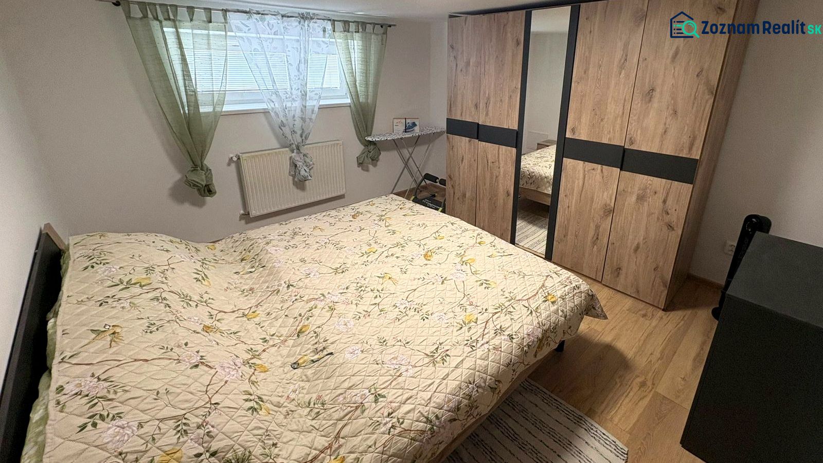 Schlafzimmer in einem Einfamilienhaus mit Holzboden, Einbauschrank und Bett.
