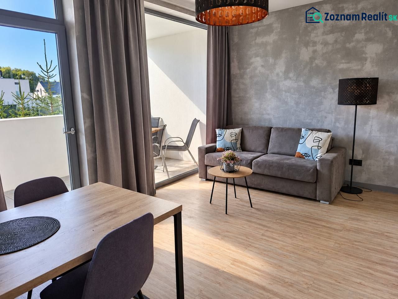 Wohnzimmer in einer 2-Zimmer-Wohnung mit Holzboden und Balkon.