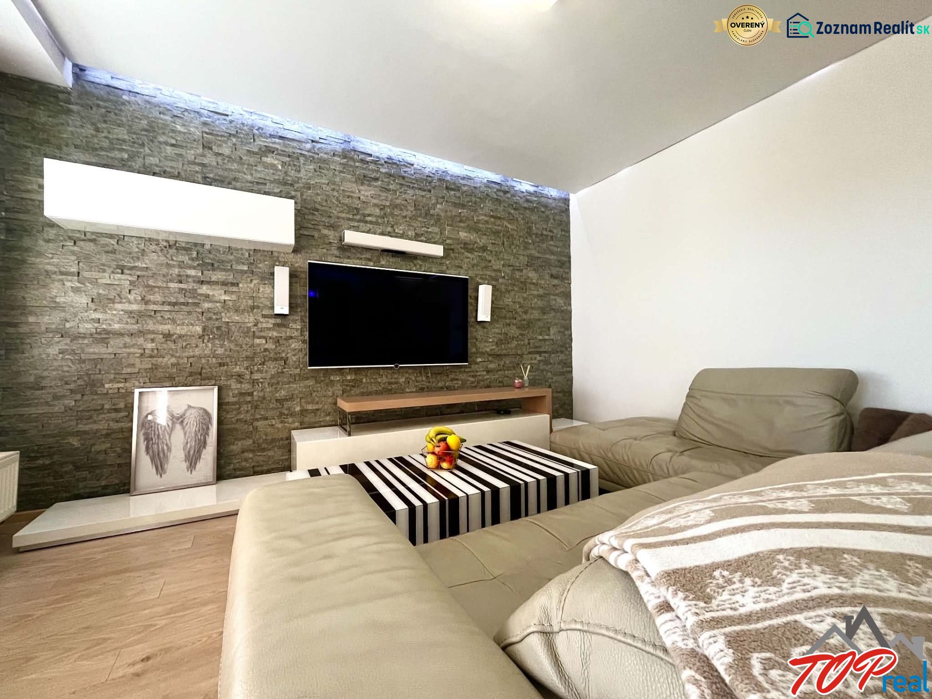 Wohnzimmer in einer 3-Zimmer-Wohnung mit Ledersofa und Holzboden.