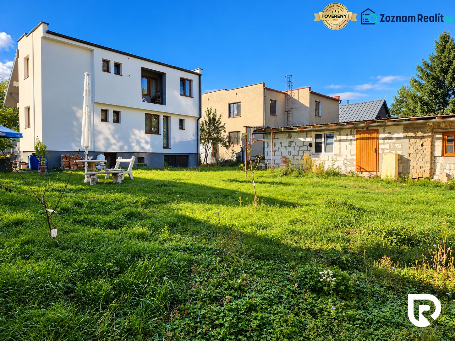 Ein Einfamilienhaus in Martin mit Garten, Terrasse und einem angrenzenden Gebäude auf einem geräumigen Grundstück.