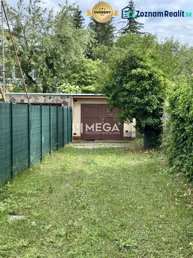 Garage in der Straße Osloboditeľov in Humenné, umgeben von Grünflächen und einem Zaun.