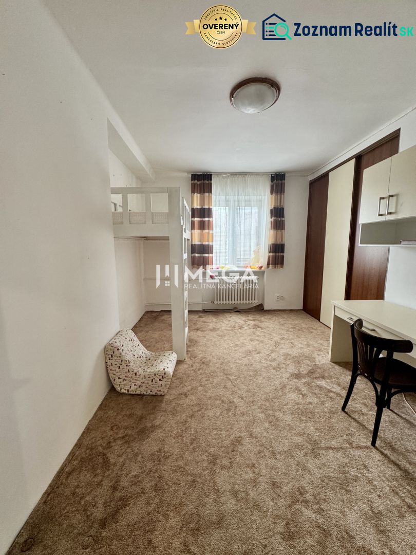 Ein Zimmer mit Teppich, Etagenbett, Schreibtisch und Stuhl in einer 3-Zimmer-Wohnung.