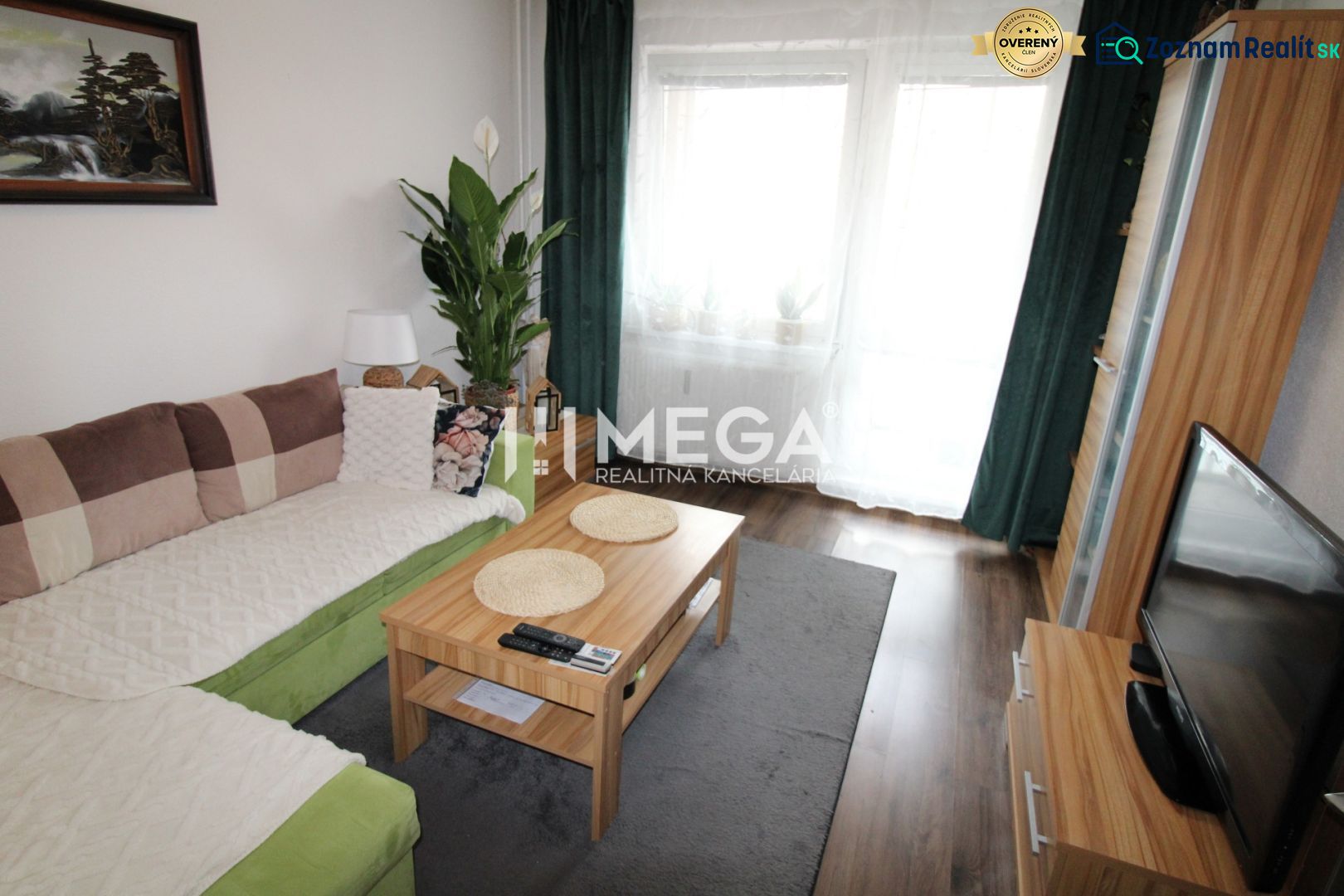 Wohnzimmer in einer 3-Zimmer-Wohnung mit Sofa, Tisch und Holzboden.