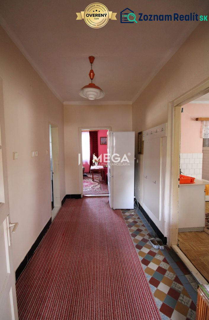 Ein Flur in einem Einfamilienhaus mit Teppichboden und einer Retro-Leuchte.