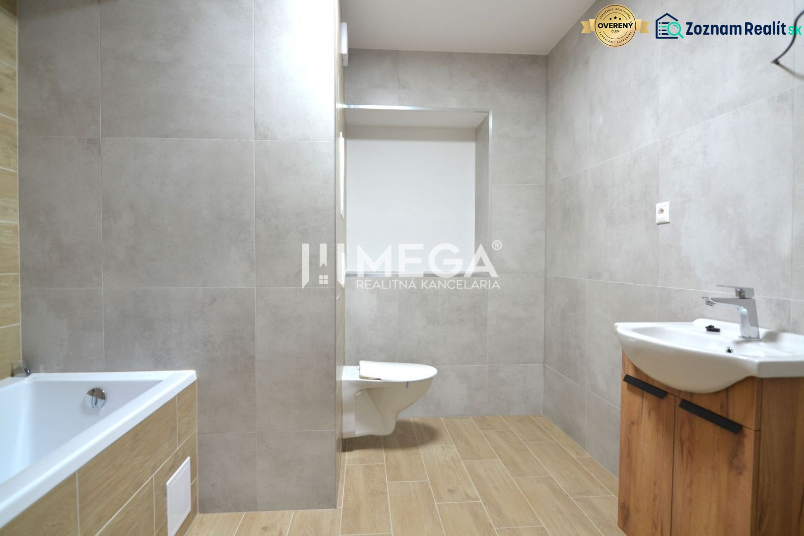 Badezimmer mit Badewanne, Waschbecken und Toilette, Boden mit Holzdekor in einer 2-Zimmer-Wohnung.