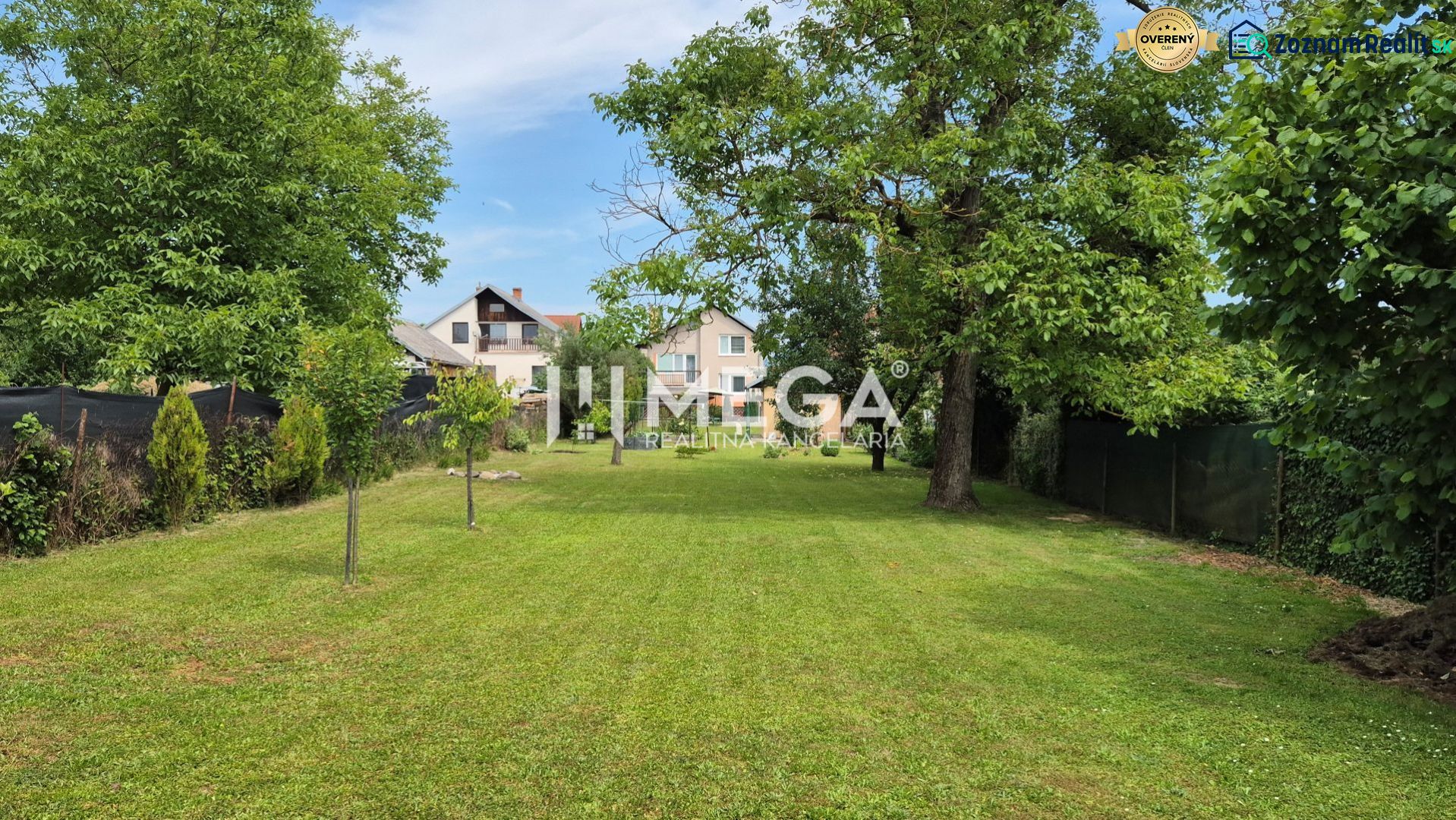 Der Garten beim Einfamilienhaus in Lackovce mit gepflegtem Rasen und Bäumen.