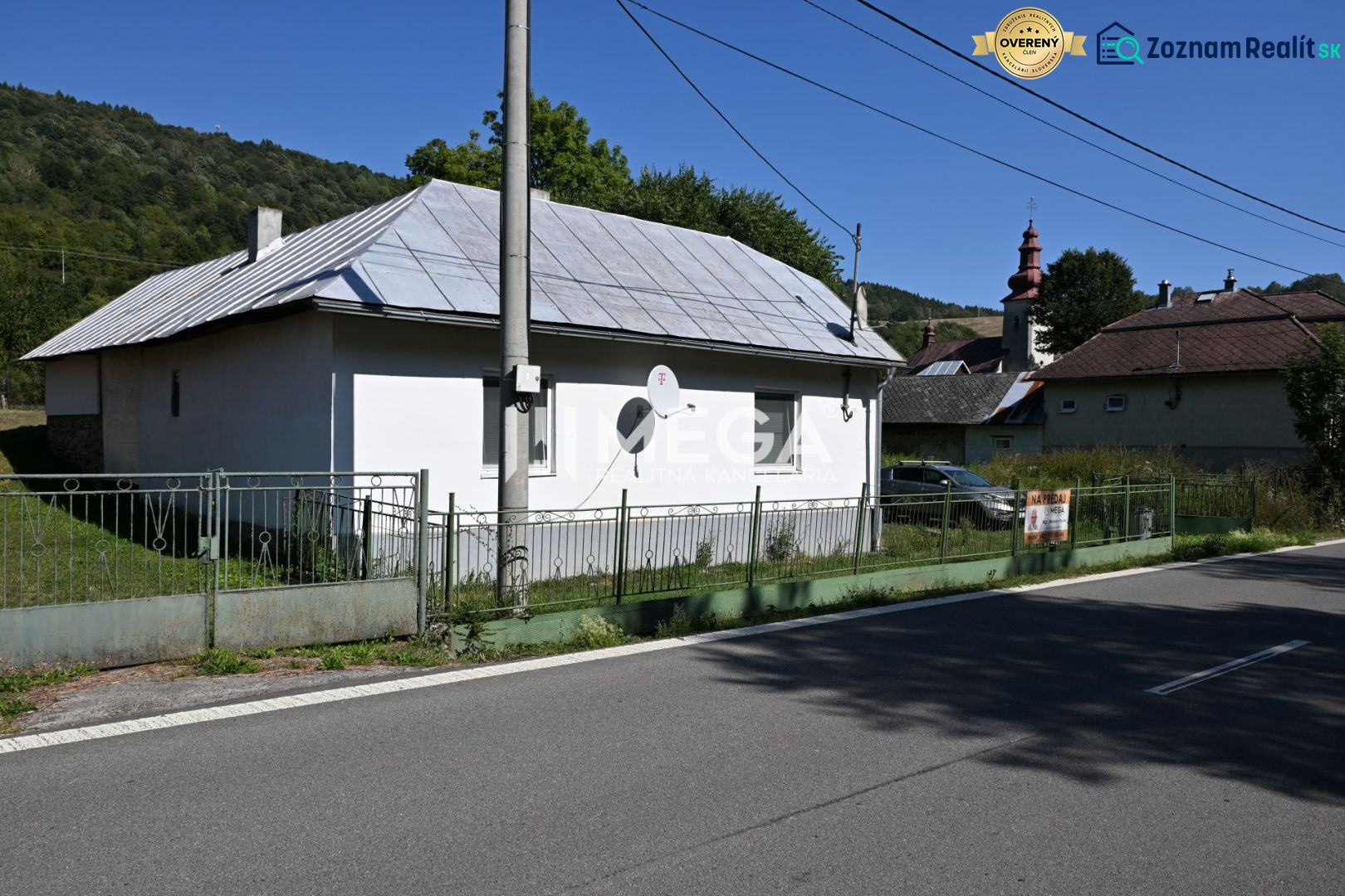 Ein Einfamilienhaus in Kolbasov in der Kolbasov-Straße, mit einem Blechdach und einem Zaun.