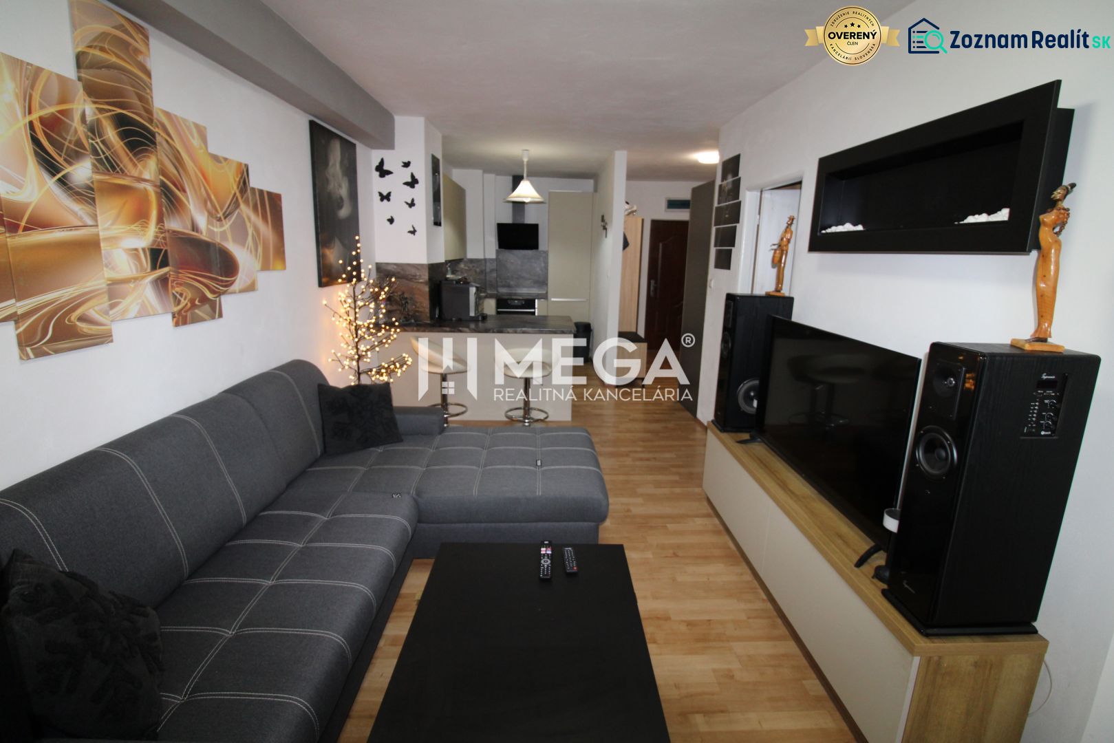 Wohnzimmer in einer 2-Zimmer-Wohnung mit Ecksofa und Boden in Holzoptik.