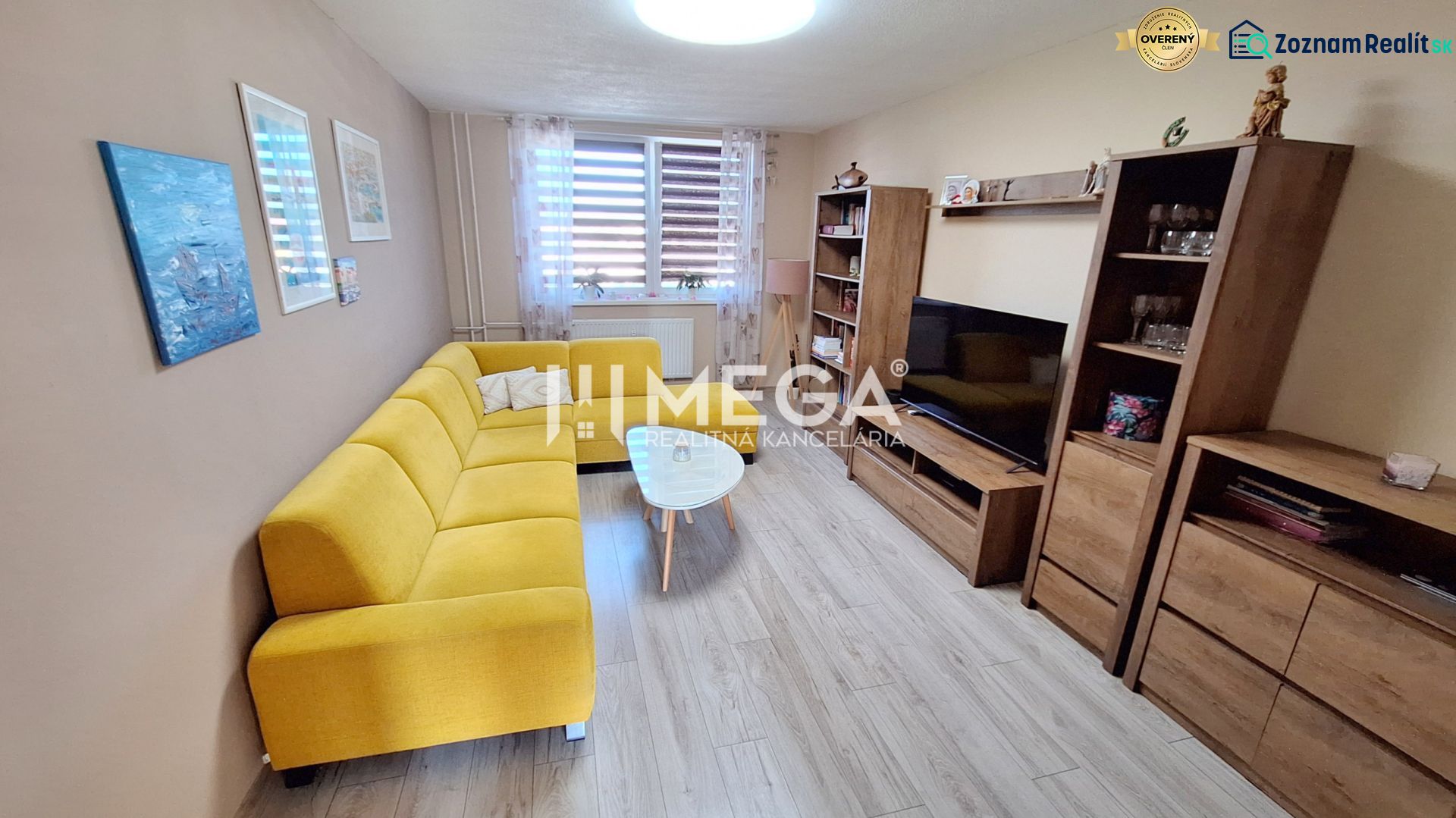 Wohnzimmer mit Holzboden und gelbem Sofa in einer 3-Zimmer-Wohnung.