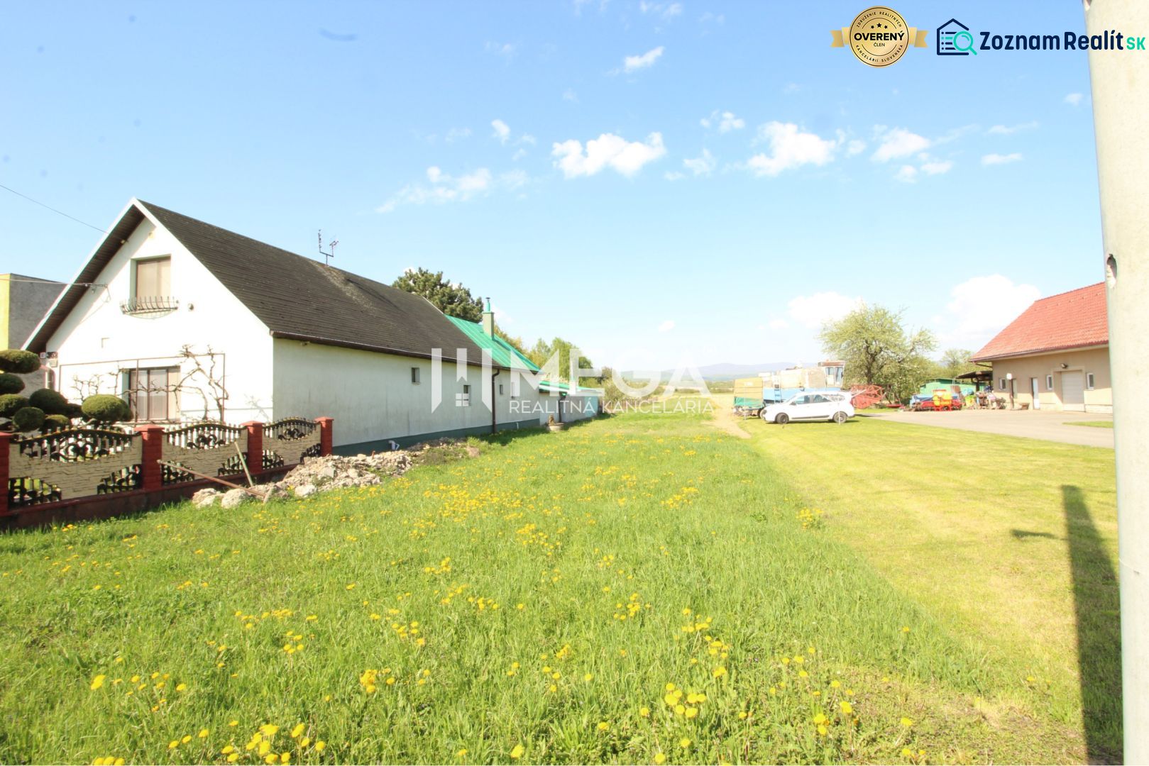 Ein Einfamilienhaus mit zwei Gebäuden und einem blühenden Rasen im Dorf Sačurov. Grundstücke - Wohnen.